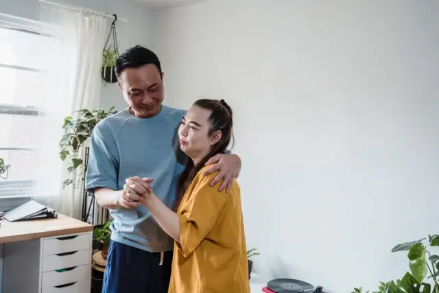 A couple dancing together at home