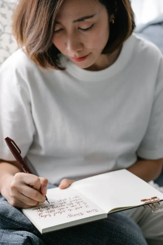 A woman writing quietly in a journal